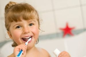 child brushing her teeth
