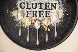 Gluten free written in flour on vintage baking sheet and spoons