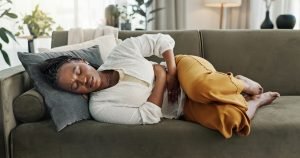 woman laying on couch with Gut Dysbiosis